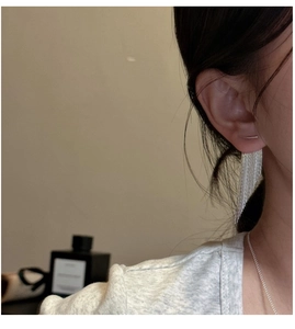 Close-up of elegant S925 sterling silver tassel earrings worn by a model in soft light
