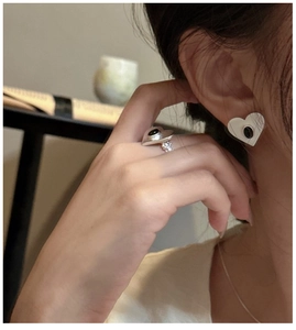 Detail view of heart-shaped S925 silver ring and earrings set with black onyx stones