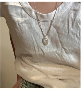 Détail d'un pendentif ovale en argent S925 avec zircon rectangulaire sur une fine chaîne