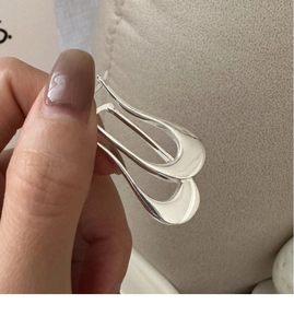 Close-up of a minimalist S925 sterling silver U-shaped hoop earring with mirror finish
