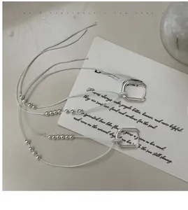 Macro detail of S925 sterling silver tassel earrings with geometric square hooks