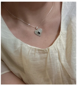 Gros plan détaillé d'un pendentif cœur en argent S925 avec une pierre d'onyx noire ovale