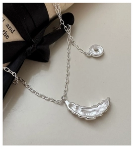 Macro shot of S925 sterling silver croissant pendant showing hallmark and chain detail