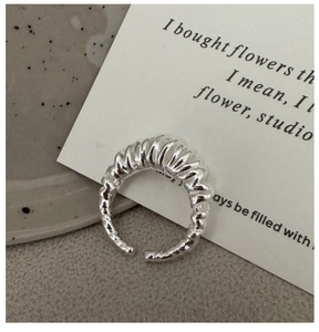 Macro shot of silver S925 sterling silver multi-layer spiral ring on stone base