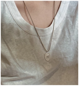 Détail du collier en argent S925 avec pendentif mat texturé et chaîne corde sur modèle