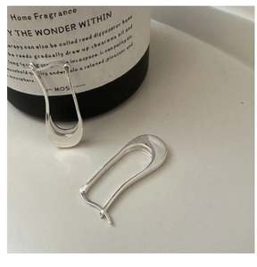 Macro shot of minimalist S925 sterling silver irregular long earrings in polished U-shape