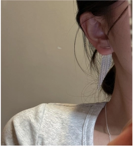 Close-up of elegant S925 sterling silver tassel earrings worn by a model in a minimalist style