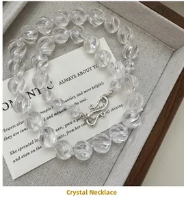 Detailed macro of crystal bead necklace with S-hook clasp on decorative card