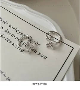 Macro shot of silver bow earring featuring S925 hallmark on minimalist silver band