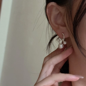 Elegant S925 sterling silver drop earrings with dual vertical pearls on a female model