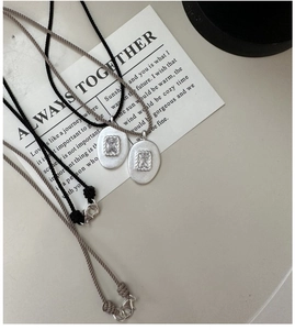 Détail du pendentif argenté martelé à la main avec zircon carré sur collier cordon