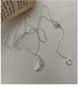 Detail of S925 sterling silver croissant pendant with textured ridges on a fine O-chain