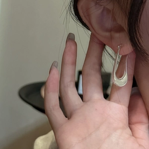 Minimalist S925 sterling silver U-shaped hoop earrings worn by a model for a sleek look
