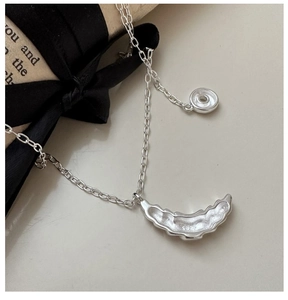 Close-up of S925 sterling silver croissant donut pendant with hallmark on chain