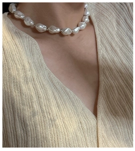 Close-up of S925 silver baroque pearl necklace worn on a cream knitted sweater