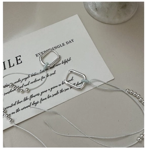 Detailed close-up of S925 sterling silver geometric rectangular tassel earrings on marble