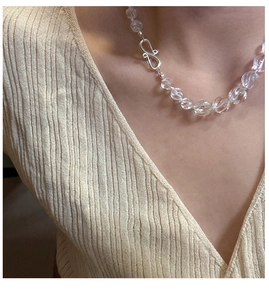 Detail of S925 silver necklace with transparent twisted crystal beads on a model collarbone