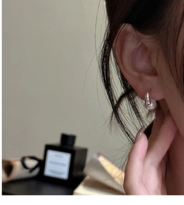 Close-up of minimalist S925 sterling silver hoop earrings with round white pearls