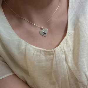Collier cœur en argent S925 avec pendentif en pierre noire porté par un mannequin