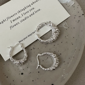Minimalist S925 sterling silver multi-layer creased hoop earrings on a ceramic tray