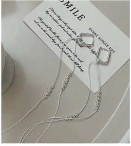 Detail of S925 sterling silver geometric rectangle earrings with long beaded tassels