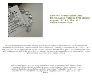 Macro detail of S925 silver heart crystal bracelet with a vintage coin queen pendant