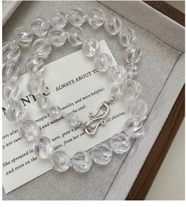 Detail of silver S-hook clasp and clear spiral crystal beads on a stylish necklace