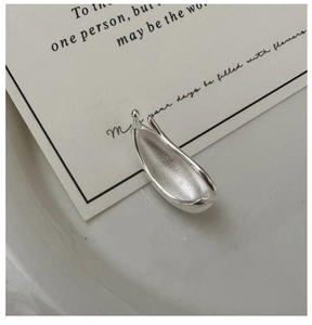 Detailed close-up of water drop ear cuff showing polished exterior and hammered inner texture