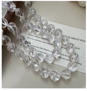 Macro detail of spiral engraved white crystal beads with translucent light reflection