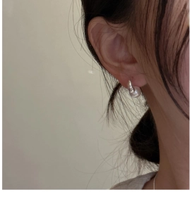 Close-up of S925 silver hook earring featuring a large white pearl worn by a model