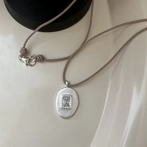 Collier avec pendentif zircon mat en argent S925 sur cordon tressé kaki, style minimaliste