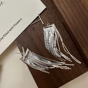 Minimalist S925 sterling silver tassel drop earrings displayed on dark wood and card