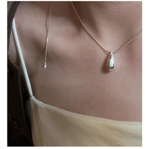 Close-up of minimalist S925 sterling silver teardrop necklace on a female model