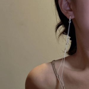 Elegant S925 sterling silver long tassel earrings with silver beads worn by a model