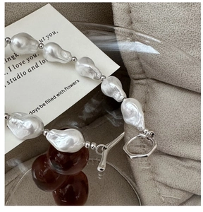 Detailed macro view of S925 silver necklace with baroque pearls and T-bar toggle clasp