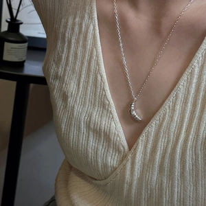 S925 sterling silver croissant pendant necklace on model with beige knit sweater