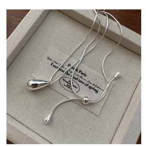 Detail of adjustable silver water drop pendant necklace on a premium display tray