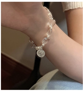 Detailed shot of S925 silver beaded heart bracelet with vintage coin pendant on wrist