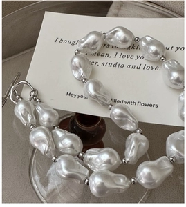 Close-up of S925 silver OT clasp and baroque pearl necklace on an elegant white card