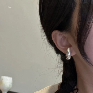 Minimalist S925 sterling silver teardrop earrings with a polished mirror finish on a model