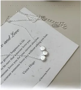 Close-up of S925 sterling silver necklace featuring three smooth round beads on fine chain