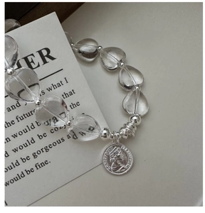 Detailed shot of S925 silver beaded bracelet with crystal hearts and Queen coin pendant
