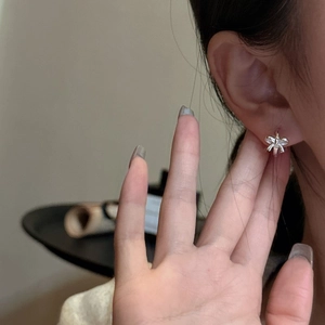 Elegant S925 sterling silver bow earrings displayed on a woman's ear for a sweet minimalist look