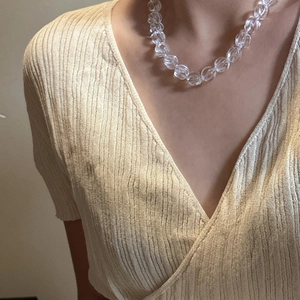 S925 sterling silver necklace featuring a clear spiral crystal pendant on a beige knit top