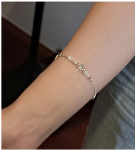 Close-up of S925 sterling silver star charm bracelet on wrist with mother of pearl beads
