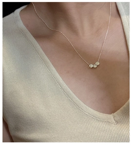Close-up of three polished gold circular pendants on a minimalist S925 silver chain necklace