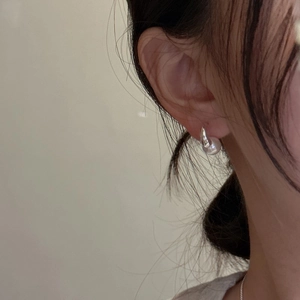 Minimalist S925 sterling silver pearl stud earrings worn on earlobe for an elegant look