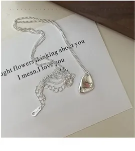 Gros plan détaillé du pendentif géométrique en argent S925 sur une chaîne de collier fine