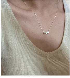Close-up of three cylindrical silver beads on a minimalist S925 sterling silver chain