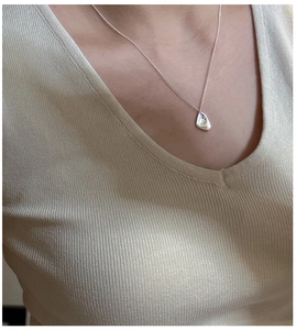 Détail du pendentif irrégulier en argent S925 sur une fine chaîne de style minimaliste